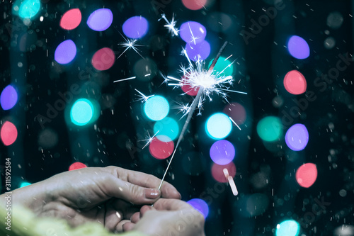 Burning sparkler in hands c...