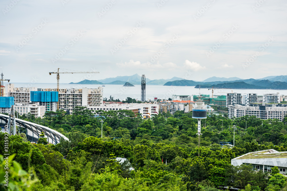 Buildings and sea at the costline of Shenzhen, view from the valley at Shenzhen Overseas Chinese Town East (OCT East) in Guangdong, China