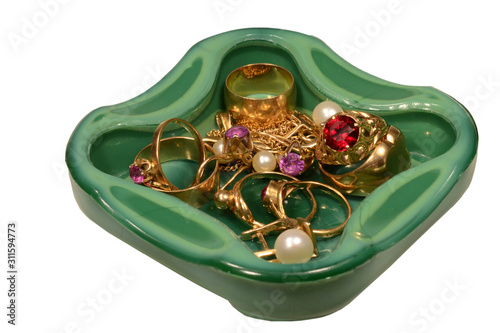 Green glass ashtray with jewelry on isolated white background