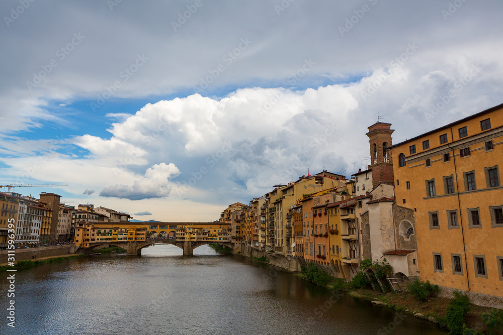 The Ponte Vecchio, a medieval stone closed-spandrel segmental arch bridge over the Arno River, in Florence, Italy, noted for still having shops built along it.  