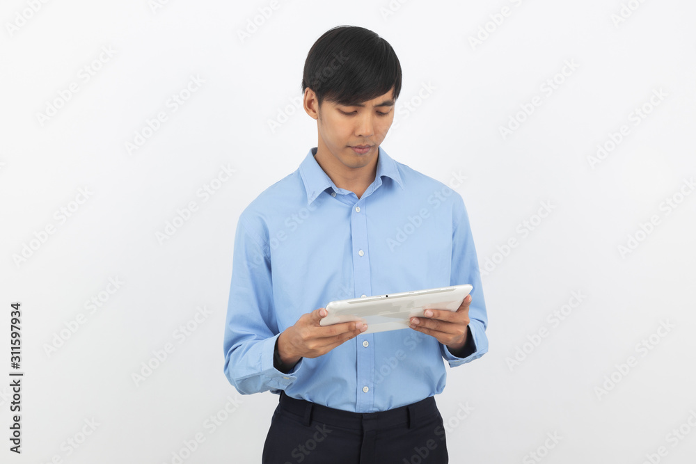 Young handsome asian business man playing and looking to tablet computer with smiling isolated on white background. Young handsome asian business man playing and looking to tablet computer with smiling isolated on white background.