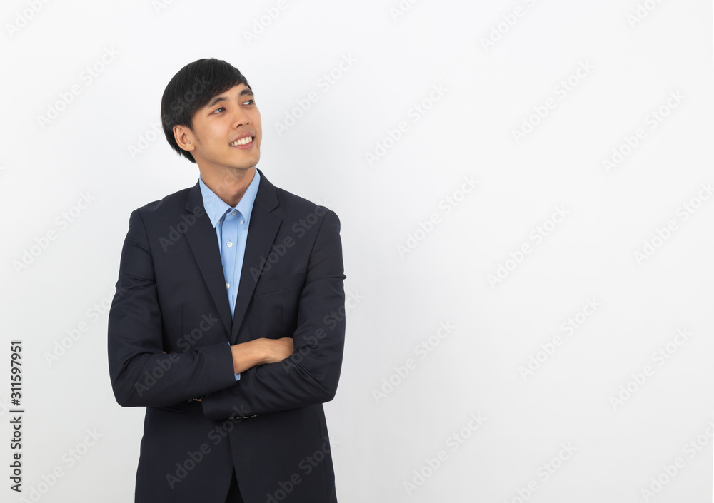 Young handsome asian man thinking an idea while looking up with arms crossed isolated on white background.