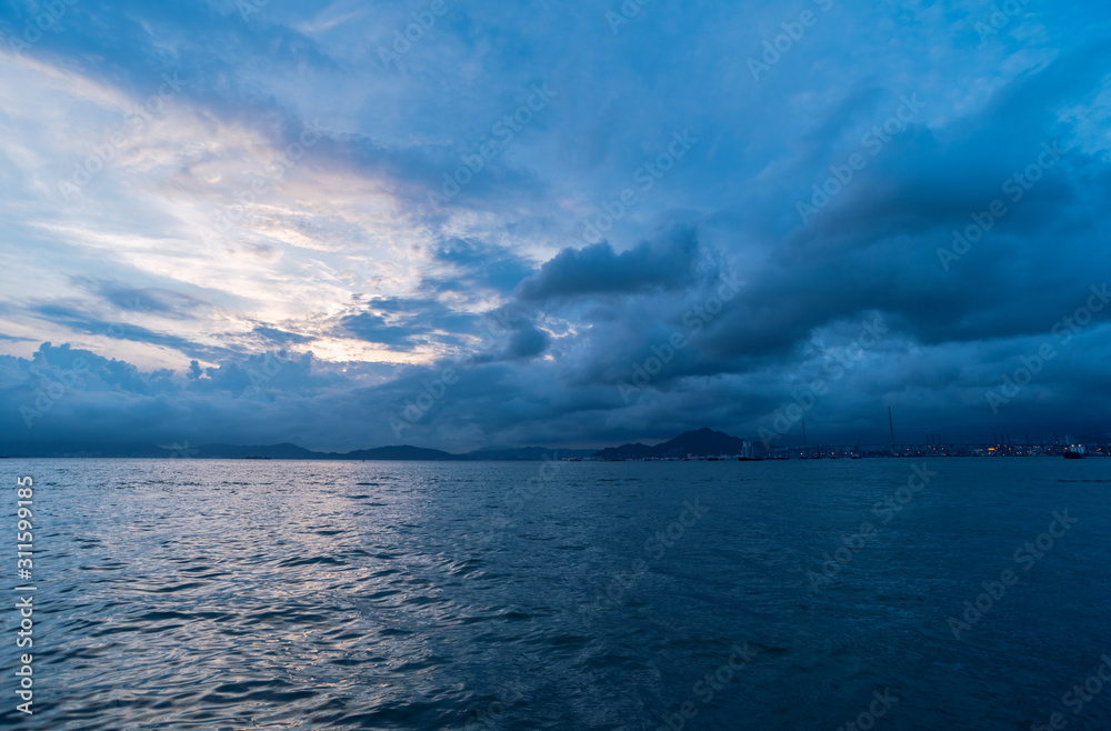 Obraz premium summer sunset landscape with an upcoming heavy storm, shot in western district public cargo working area of hong kong china