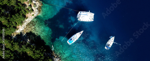Aerial drone ultra wide photo of sail boats docked in paradise bay of Fiskardo, Kefalonia island, Ionian, Greece © aerial-drone
