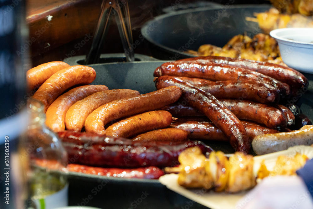 Prague, Czech Republic 2019:Traditional hot dog preparation on coal fire on the street during the Christmas market Prague, Czech Republic 2019:Traditional hot dog preparation on coal fire on the street during the Christmas market