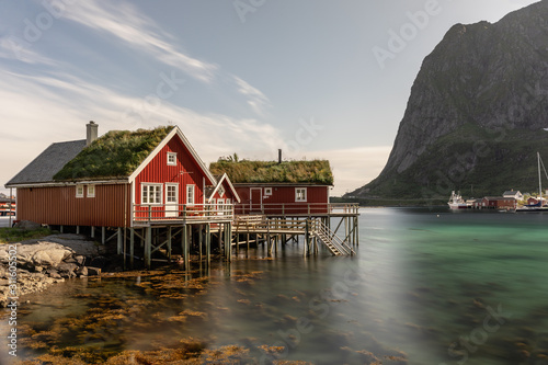 Obraz na plátně Long exposure of a red rorbuer with grassy roof in Lofoten