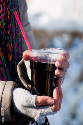 girl holding a glass of mulled wine outdoors during winter