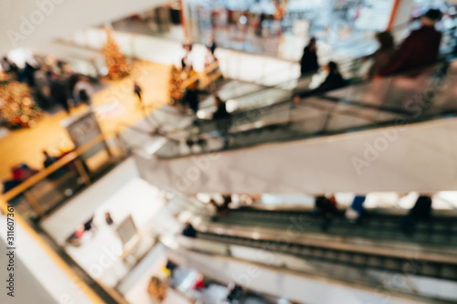 Abstract blurred background of the shopping center. Unfocused escalators with people