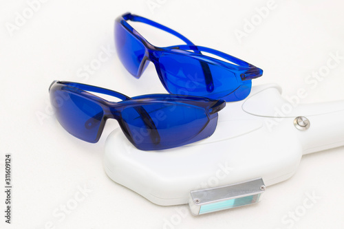Laser apparatus for hair removal, depilation. and blue safety glasses, UV protection. The concept of depilation, smooth skin, health.