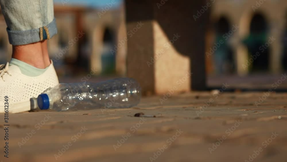 A person drops empty plastic bottle on the street . Environmental pollution concept A person drops empty plastic bottle on the street . Environmental pollution concept