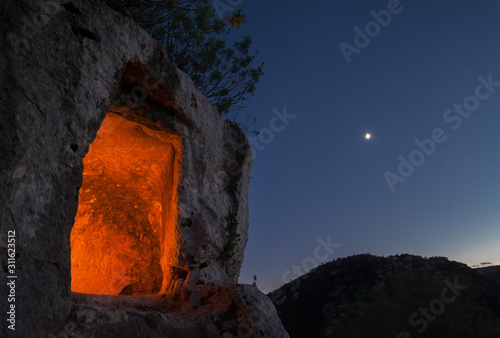Grotto by night: view of an enlightened rocky tomb at dusk, Pantalica necropolis, Sicily photo