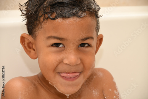 Toddler sticks his tongue out at bathtime
