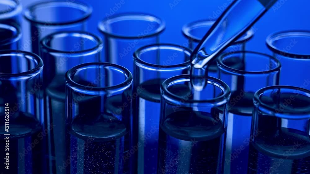 Pipette dropping sample into test tube blue light Pipette dropping sample into test tube blue light