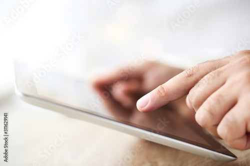 Male hands holding and using tablet computer