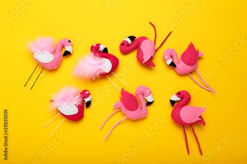Soft toy of flamingos on yellow background