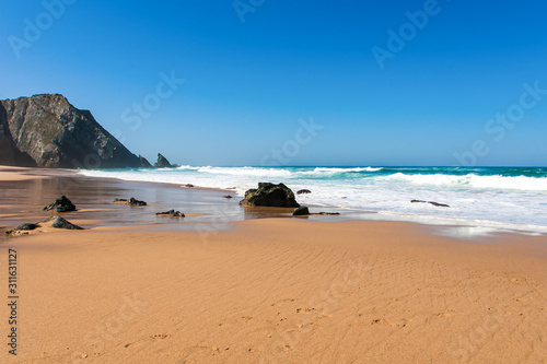 Big breaking Ocean wave on a sandy beach on the west shore of Portugal photo