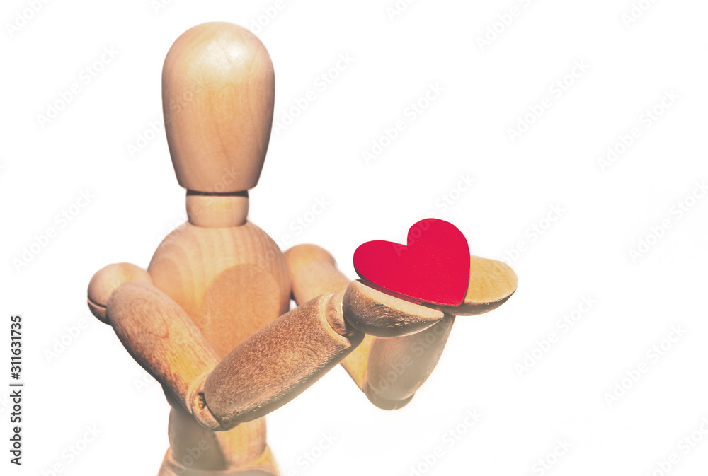Wooden mannequin with red heart. Wooden mannequin holds a heart in his hands, copy space. Concept of love and Valentine's Day. Wooden mannequin with red heart. Wooden mannequin holds a heart in his hands, copy space. Concept of love and Valentine's Day.