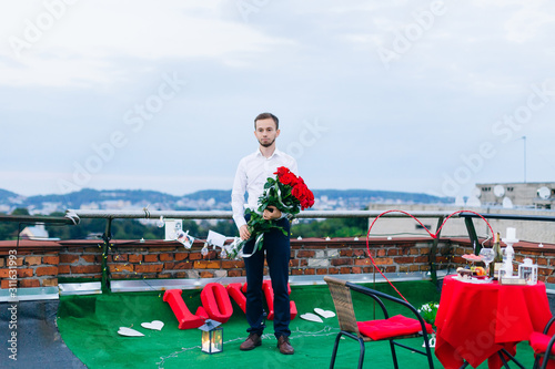 The guy in festive clothes stands on the roof of the building an