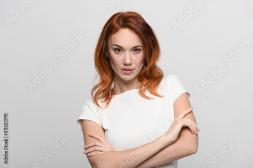 portrait of young woman, isolated on white. Red hair, beautiful eyes and lips, model appearance, waist-length shot in light beidge-white dress with short sleeves