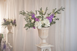 White large vase with flowers on the background of a white curtain 2203.