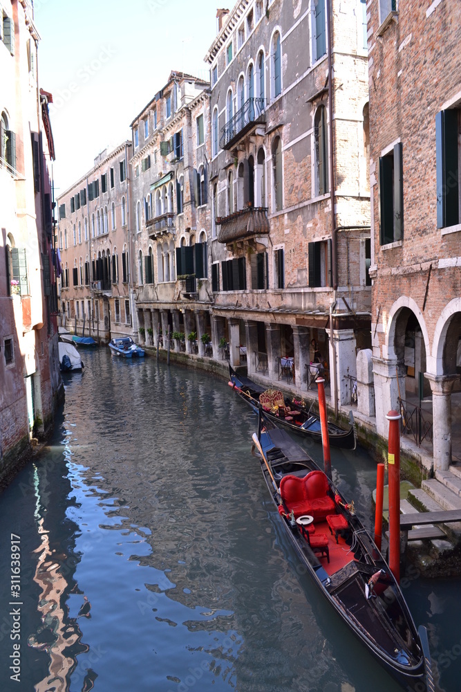 Traditional venetian cityscape. View of the canal, ancient buildings and the gondola.