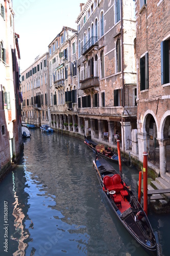Traditional venetian cityscape. View of the canal, ancient buildings and the gondola.