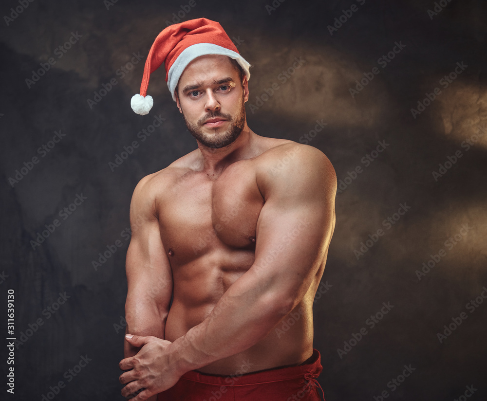 In the smoky photo studio a young nude male is posing for photographer in  santa claus role. Stock Photo | Adobe Stock