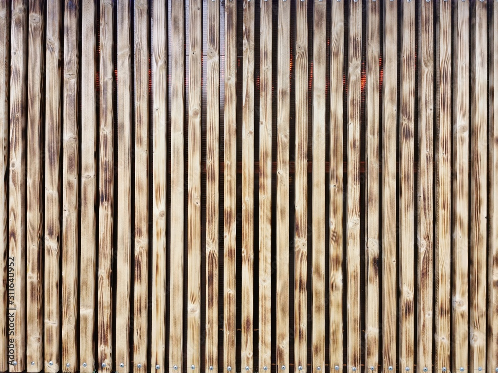 Wooden thin slats with traces of firing. Thin vertical slats.Wooden background. Wooden thin slats with traces of firing. Thin vertical slats.Wooden background.