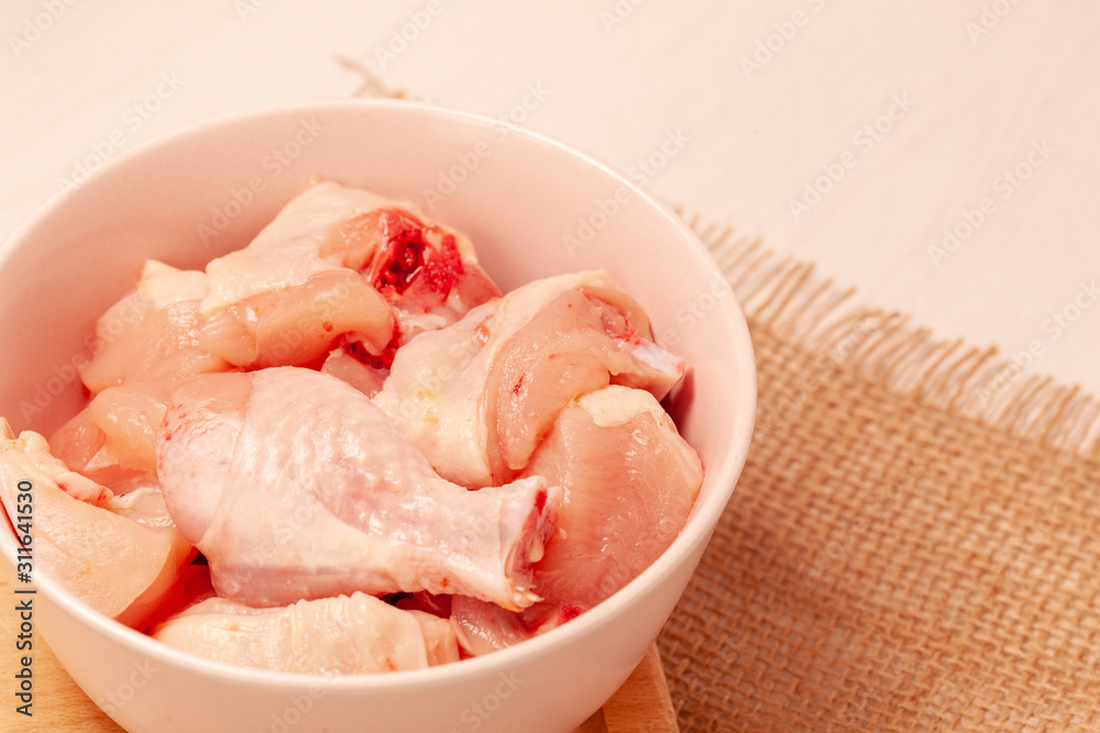 raw chicken in bowl on jute cloth background raw chicken in bowl on jute cloth background