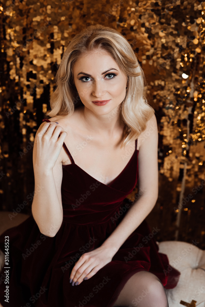 Elegant lady in dress over gold background. Happy new year. Model posing in studio. Winter holidays concept. Elegant lady in dress over gold background. Happy new year. Model posing in studio. Winter holidays concept.