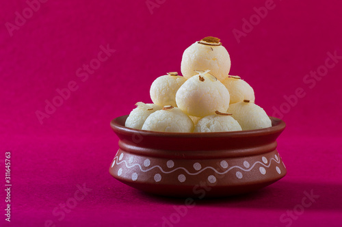 Indian Sweet or Dessert - Rasgulla, Famous Bengali sweet in clay bowl on a pink background. photo