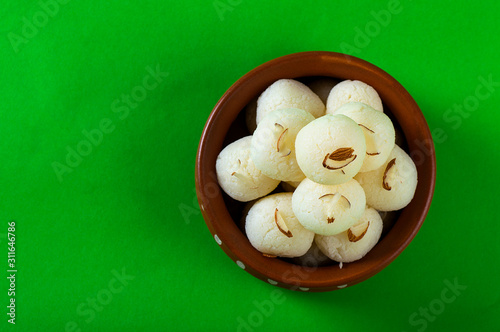 Indian Sweet or Dessert - Rasgulla, Famous Bengali sweet in clay bowl on green background photo