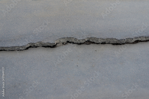 Crack in the asphalt road close-up. Danger to traffic.