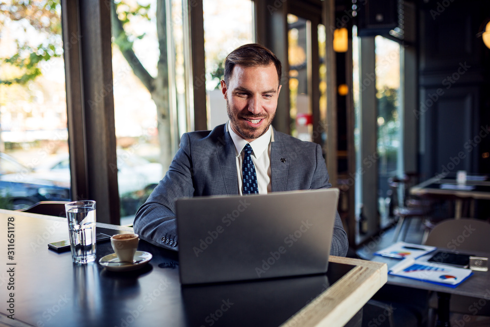 Professional businessman sitting in cafe and using laptop Professional businessman sitting in cafe and using laptop