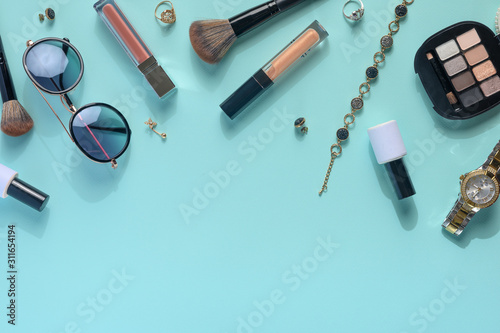 Women's accessories, a background from women's cosmetics, with creative color. A frame for writing. Creative light. Blue background.
