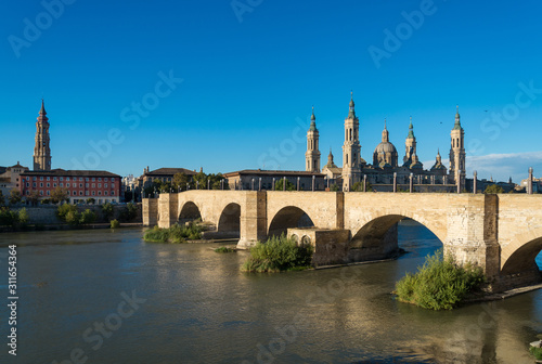 Puente de Piedra bridge across the river Ebro and the ancient church Basilica del Pillar in the Spanish city Zaragoza