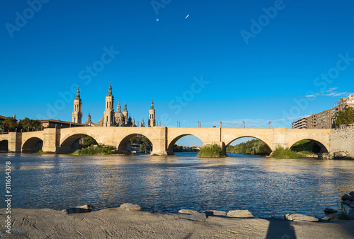 Fototapeta Puente de Piedra bridge across the river Ebro and the ancient church Basilica de