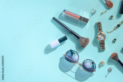 Blogging Beauty Concept. Professional female makeup accessories, watches, bracelet, glasses on a blue background. Female background and fashion. Instagram, women's stuff. Flat lay banner