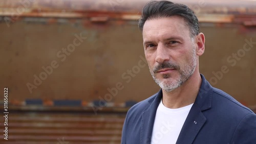 Hombre de mediana edad en primer plano mirando a camara con seguridad