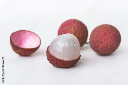 Unhusked litchi on a white background.