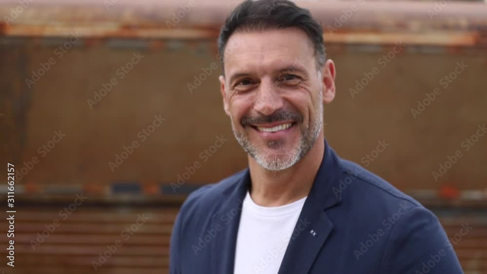 Hombre de mediana edad en primer plano mirando a cámara sonriente en 