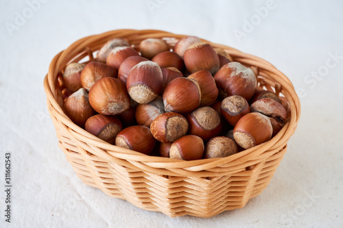 Hazelnuts in a basket on a light background