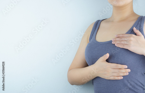 Woman hands doing breast self-exam for checking lumps and signs of breast cancer on white background. Health care and medical concept.
