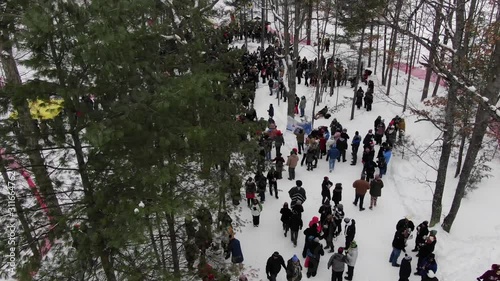 Winter party in the woods in Traverse City Michigan 4K drone shots over forest and open woods in winter snow covered scene people at event photo