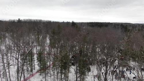 Winter party in the woods in Traverse City Michigan 4K drone shots over forest and open woods in winter snow covered scene people at event in the woods photo