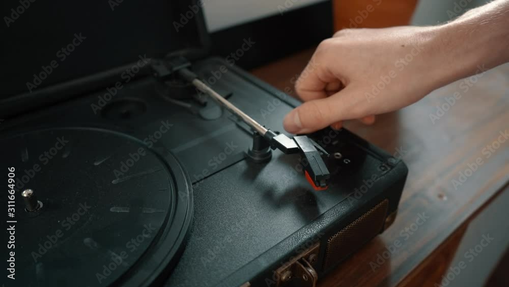 A hand turns on a turntable.