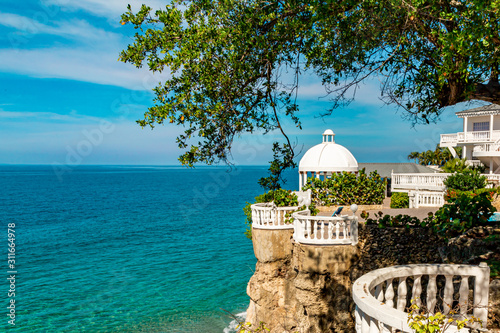 Beautiful white gazebo and tropical flower garden on Caribbean ocean background, summer mountain view , Sosua, Puerto Plata, Dominican Republic