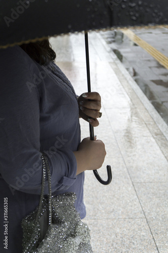 woman waiting for someone with umbrella