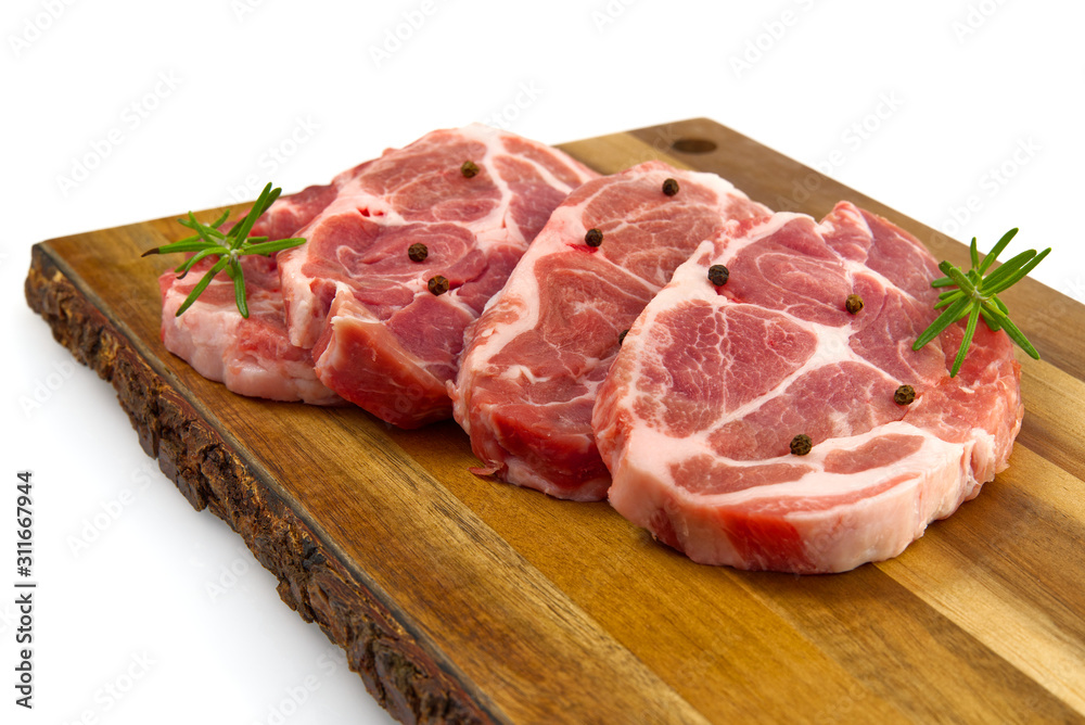 raw pork steak on wood cutting board. Pork with spices: rosemary and pepper. Close-up raw pork steaks. raw pork steak on wood cutting board. Pork with spices: rosemary and pepper. Close-up raw pork steaks.