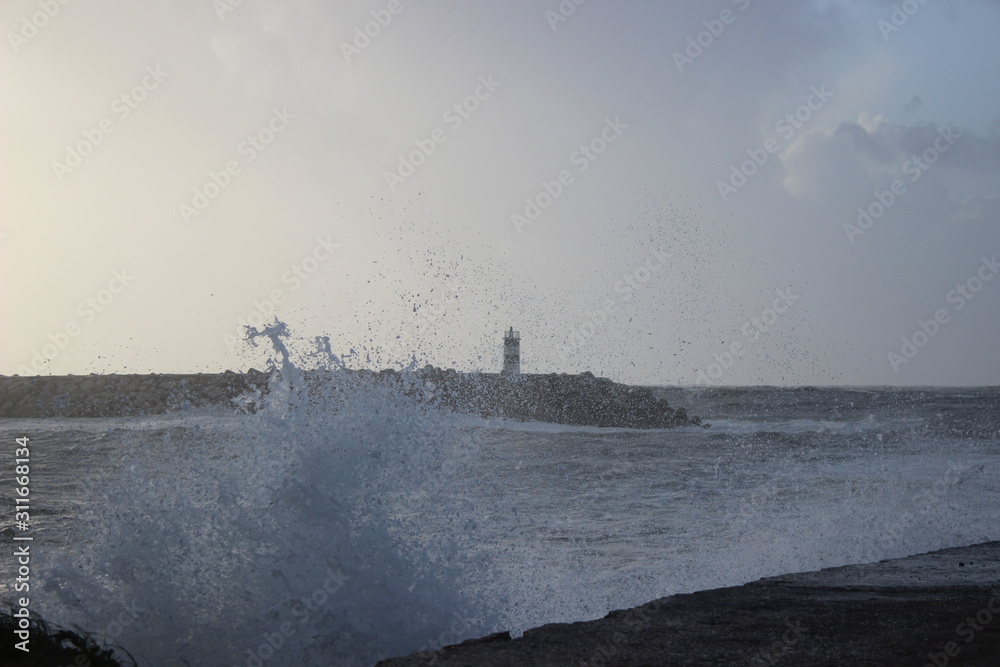 Clashing wave with lighthouse in the background